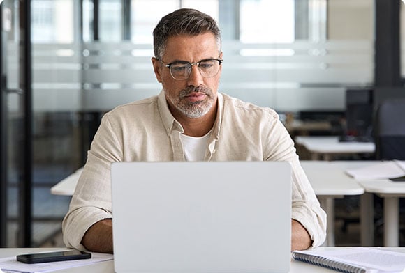 A man checks his laptop in his office