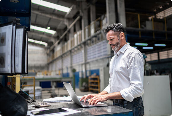 Man checks computer system in warehouse