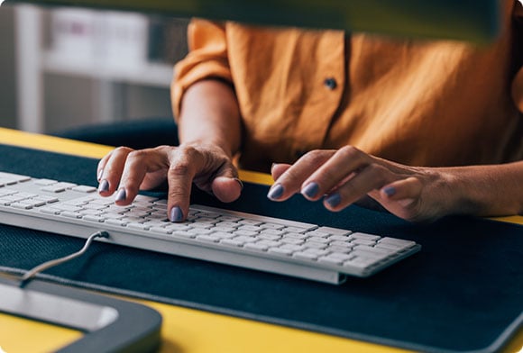 A worker types on their keyboard at their desk