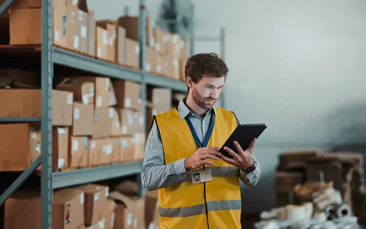 Warehouse worker in tablet using warehouse management software